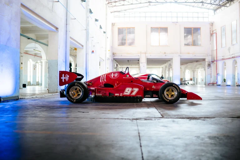 Monoposto rossa nella grande sala industriale
