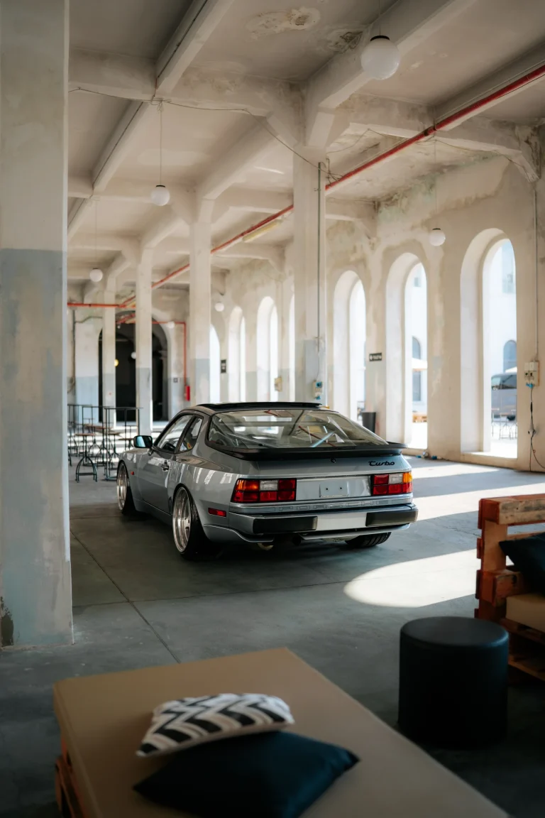Automobile classica chiara tra finestre e colonne